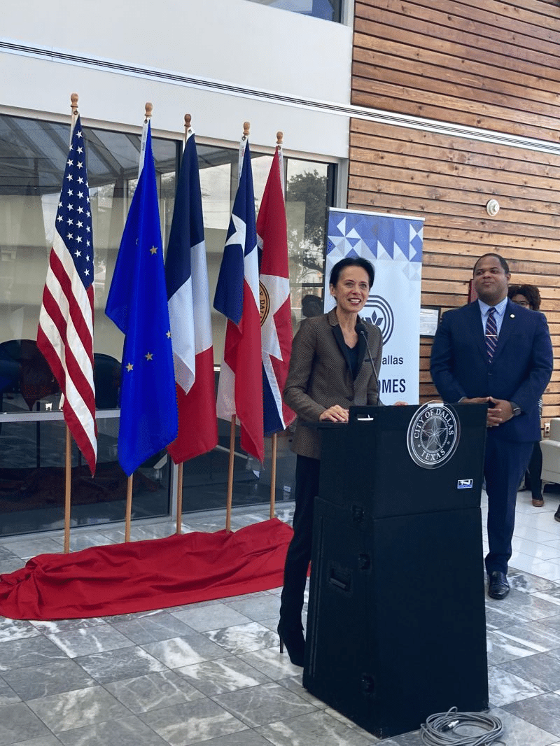 Valérie Baraban, Consul General of France in Houston, speaking at the podium at the FACC Trade Office Opening in Dallas, with Mayor Eric Johnson in the background, December 5, 2022
